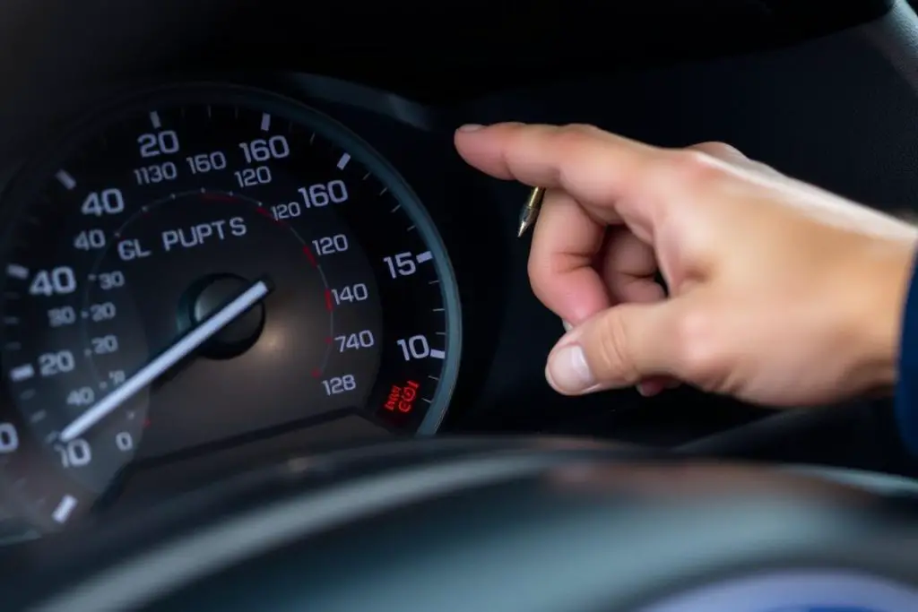 Person checking Ford Fusion oil level with dipstick Person checking Ford Fusion oil level with dipstick